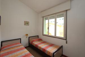 um quarto com 2 camas e uma janela em Dolomiti em Bibione