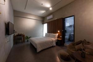 a hotel room with a bed and a bathroom at 木子寓所 Moozhouse in Magong