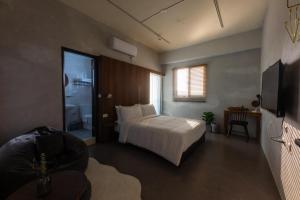 a hotel room with a bed and a bathroom at 木子寓所 Moozhouse in Magong