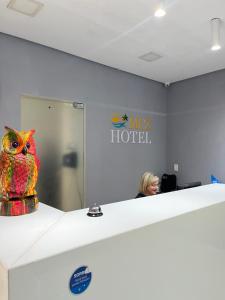 uma mulher num escritório com uma coruja numa prateleira em Mcz Hotel em Maceió