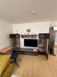 a living room with a flat screen tv and a desk at La Luna in Beuren