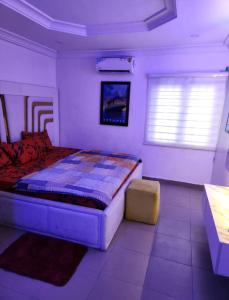 sypialnia z dużym łóżkiem i oknem w obiekcie Kings Lux Home w mieście Lagos