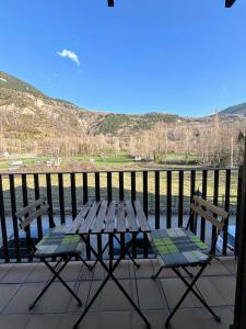 a picnic table and two chairs sitting on a balcony at Apartamentos Nogueret in Benasque