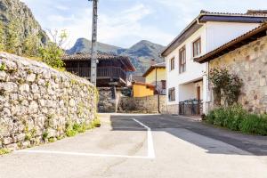 a street with a stone wall next to a building at La Olivia 53 Boutique con zona Chill Out A 5 min de Cangas de Onís in Cangas de Onís