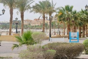 a park with palm trees and a bench and lights at KUBA LuXuS - VillA in Sahl hashesh-hurghada in Hurghada