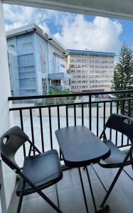 2 sillas y una mesa en el balcón en Krystal Claine Homestay-BURNHAM HILL en Baguio
