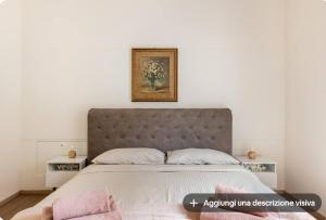 a bedroom with a large bed with a picture on the wall at Vittoria room in Bardolino