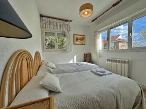 two beds in a bedroom with two windows at Chalet Pitu - 17801 in Piedrahita