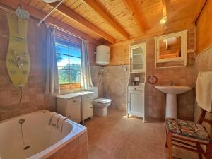 a bathroom with a tub and a toilet and a sink at Chalet Pitu - 17801 in Piedrahita +53 photos
