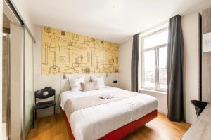 a bedroom with a large bed and a chair at Hotel Het Menneke in Hasselt