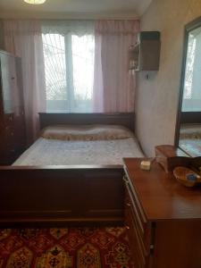1 dormitorio con 1 cama con tocador y ventana en 2-ух комнатная квартира en Baku
