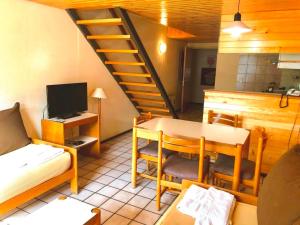a living room with a table and a staircase at Apartur Las Leñas in Las Lenas