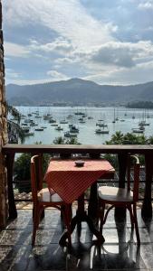a table and chairs on a balcony with a view of a harbor at Mansão Espetacular Angra in Angra dos Reis