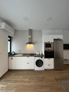 uma cozinha com armários brancos, um lavatório e um frigorífico em Precioso estudio en les Corts Valencianes em Valência