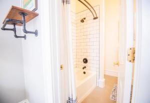 uma casa de banho branca com uma banheira e um chuveiro em Condo Off Dickson - Walk to Dickson em Fayetteville