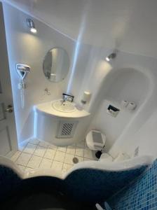 a white bathroom with a sink and a mirror at VITAMIN STUDIO in Oia