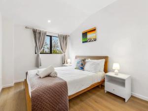 a bedroom with a large bed and a window at Wonderful Three Bedroom with Garage in Auckland