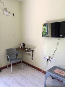 Camera con scrivania, sedia e TV. di KwetuNyumbani away from Home a Mombasa