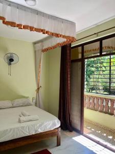 una camera con un letto e una grande finestra di KwetuNyumbani away from Home a Mombasa