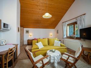Ubytovanie Clematis في ترينتشياسكي تيبليسي: غرفة معيشة مع أريكة صفراء وطاولة