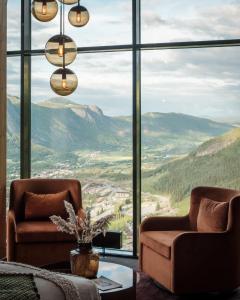 Habitación con 2 sillas y ventana grande con vistas a las montañas. en Skarsnuten Mountain Resort & SPA en Hemsedal