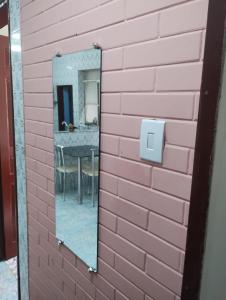 un espejo en una pared de ladrillo rosa con una mesa en Casa perto de tudo, pra você ter ótima experiência. Bora Conhecer Ouro Preto.... en Ouro Preto