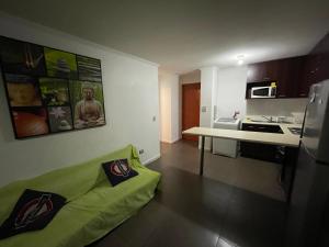 a living room with a green couch in a kitchen at VISTA LA CIUDAD Y MAR PISO ALTO 1D in Antofagasta