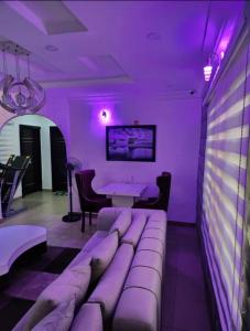fioletowy pokój z kanapą i stołem w obiekcie Kings Lux Home w mieście Lagos