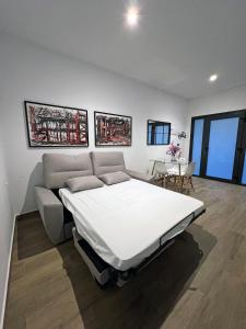 a white room with a bed and a table at Precioso estudio en les Corts Valencianes in Valencia