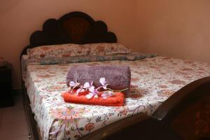 a bed with a blanket on top of it at Casa de Sekara Near White Town in Puducherry