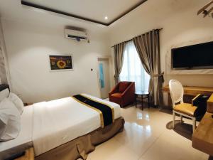 a bedroom with a bed and a desk and a television at Chevilly Resort & Camp in Bogor