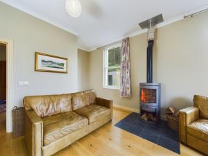 a living room with a couch and a wood stove at Mourne Mountain Bliss, Rostrevor 4BR Cottage with Patio & BBQ ideal for a relaxing getaway in Rostrevor