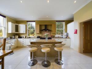 a kitchen with a large island with bar stools at Mourne Mountain Bliss, Rostrevor 4BR Cottage with Patio & BBQ ideal for a relaxing getaway in Rostrevor
