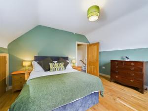 a bedroom with a large bed with a blue headboard at Mourne Mountain Bliss, Rostrevor 4BR Cottage with Patio & BBQ ideal for a relaxing getaway in Rostrevor