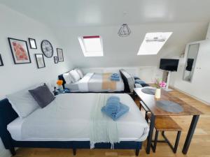 Habitación con cama, mesa y sofá en Bright Studio in Wembley 30min to Central London, en Londres