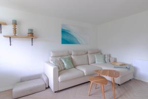 a living room with a white couch and a table at Küstennest in Timmendorfer Strand