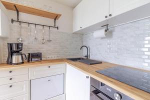 a kitchen with white cabinets and a sink at Küstennest in Timmendorfer Strand