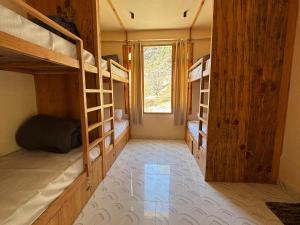 a room with several bunk beds and a window at Grham Hostel Kasol, Katagla in Kasol