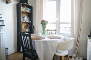 a dining room table with a vase of flowers on it at Cozy love nest near the Eifel Tower in Paris
