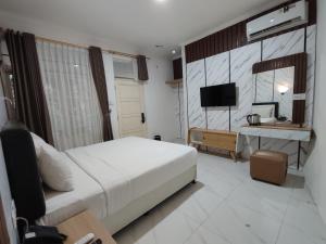a hotel room with a bed and a television at Chevilly Resort & Camp in Bogor