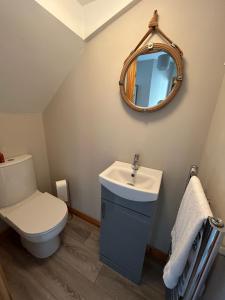a bathroom with a toilet and a sink and a mirror at Hopefield House, Portrush in Portrush