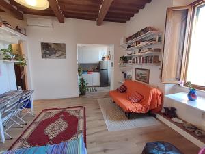 ein Wohnzimmer mit einem orangenen Stuhl und eine Küche in der Unterkunft La casa di Fabri in Piombino