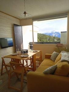 a living room with a couch and a table at Appartement avec belle vue sur montagne in Égat