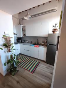 eine Küche mit weißen Schränken und einem Teppich auf dem Boden in der Unterkunft La casa di Fabri in Piombino
