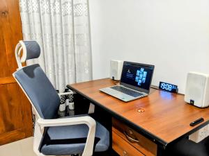 a laptop computer sitting on a wooden desk with a chair at Lavish Lodge, Tangalle, Sri Lanka in Tangalle