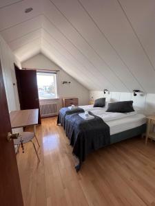 a bedroom with a large bed in a attic at Setrið Guesthouse in Borgarnes