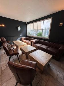 a room with couches and tables and a window at Le Concept Hotel in Les Portes