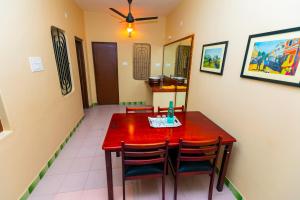 a dining room with a red table and chairs at Casa de Sekara Near White Town in Puducherry