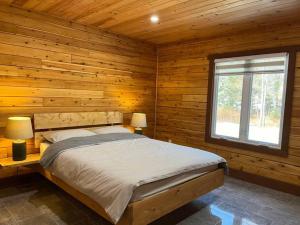 een slaapkamer met een bed in een blokhut bij Geese Villa Log House in Harrington