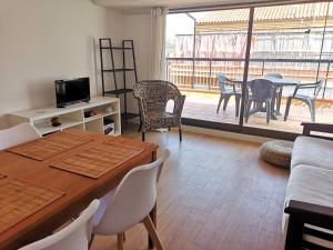 a living room with a table and chairs and a balcony at ApartEasy - Atic Sants in Barcelona